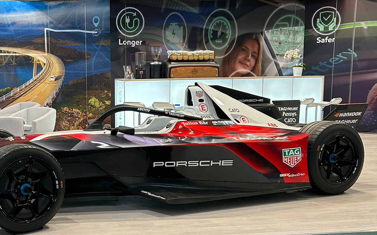 Messestand mit einem Rennwagen im Vordergrund | Kaffee-Catering - Messe